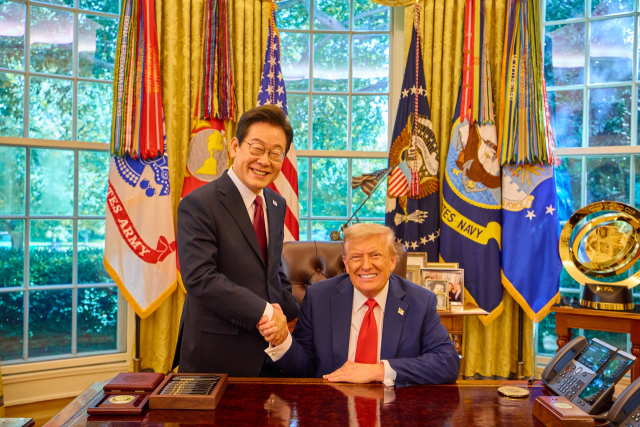이재명 대통령이 25일(현지시간) 미국 워싱턴DC 백악관 오벌오피스에서 열린 한미 정상회담뒤 도널드 트럼프 미국 대통령과 악수하며 미소짓고 있다. 연합뉴스