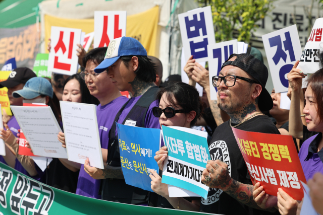 대한문신사중앙회 회원들이 27일 서울 여의도 국회 앞에서 문신 합법화 촉구 기자회견을 열고 있다. 이들은 이날 국회 보건복지위원회 전체회의에서 논의되는 문신사법의 통과를 촉구하는 동시에 국민과 의료계의 우려에 적극적으로 화답하겠다며 문신사 직업윤리강령을 선포했다. 연합뉴스