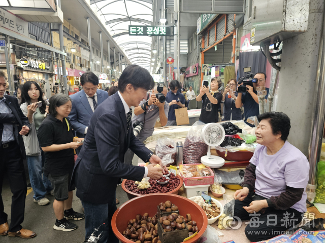 조국 조국혁신당 혁신정책연구원장이 포항 죽도시장에서 한 상인으로부터 밤 등 간단한 간식거리를 구매하고 있다. 신동우 기자