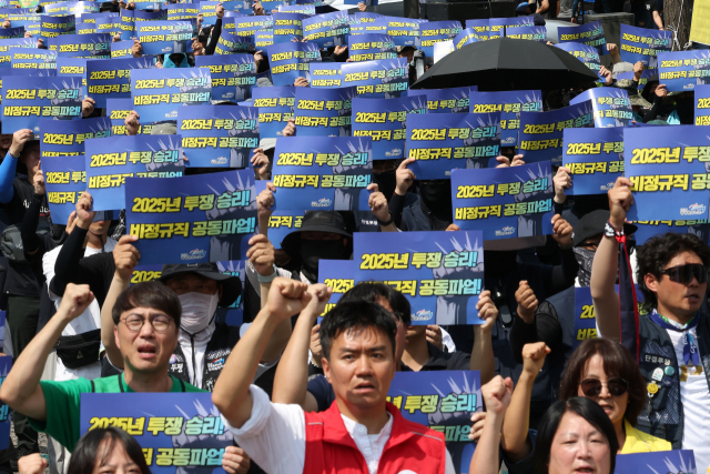 27일 서울 용산구 삼각지역 인근에서 열린 발전 비정규직 노동자 총파업대회에서 참가자들이 손팻말을 들고 있다. 연합뉴스
