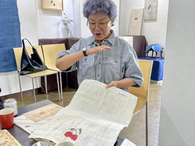 김춘희 여사가 무삼 작품에 대해 설명하고 있다. 30년 넘게 쓴 이불의 낡고 떨어진 부분을 잘라내고 쓸만한 부분을 골라 베갯잇으로 만들었다. 이연정 기자