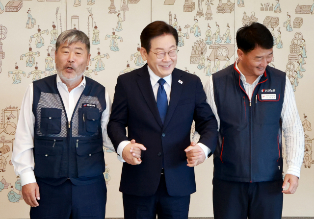 이재명(가운데) 대통령이 지난 4일 용산 대통령실 청사에서 열린 양대노총 위원장과의 오찬 간담회에 참석해 김동명(왼쪽) 한국노총 위원장, 양경수 민주노총 위원장과 손을 잡고 있는 모습. 연합뉴스