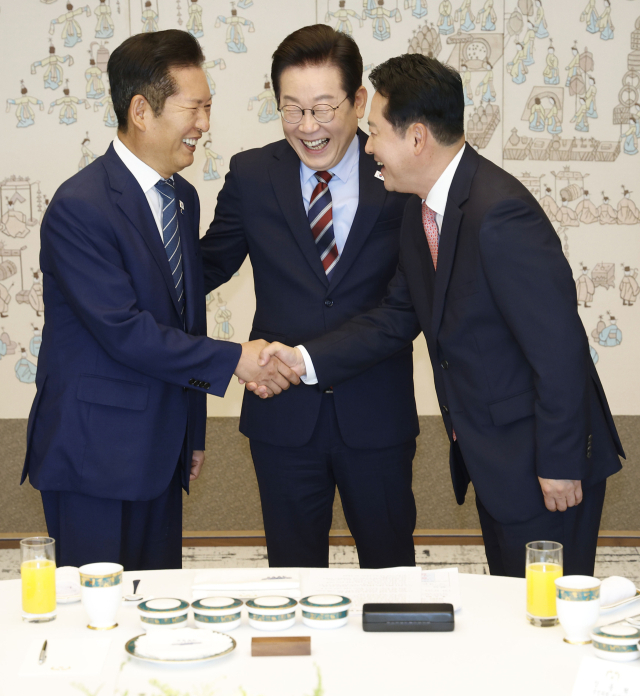이재명 대통령이 8일 용산 대통령실에서 여야 지도부 오찬 회동에 참석한 더불어민주당 정청래 대표와 국민의힘 장동혁 대표가 악수하는 모습을 보고 있다. 연합뉴스