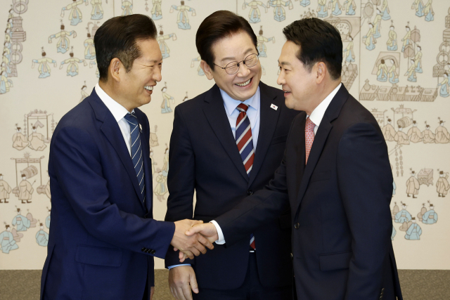 이재명 대통령이 8일 용산 대통령실에서 여야 지도부 오찬 회동에 참석한 더불어민주당 정청래 대표와 국민의힘 장동혁 대표가 악수하는 모습을 보고 있다. 연합뉴스