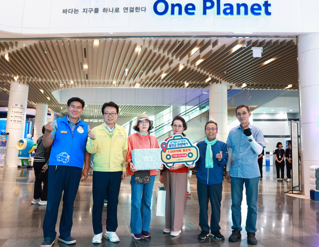 1천번째 울진관광택시 탑승객이 울진군으로부터 기념품을 받고 있다. 울진군 제공