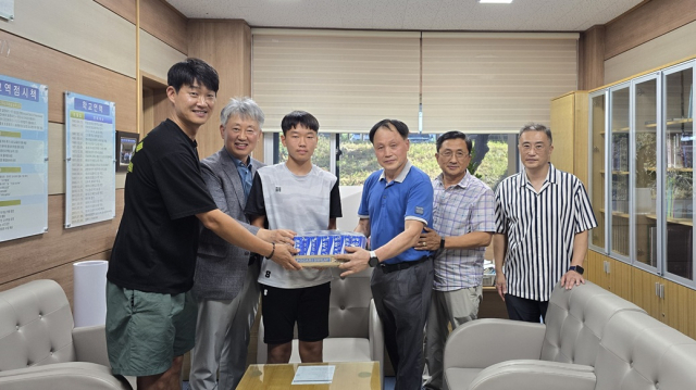청송 진성중학교 12회 졸업생인 권중돈 씨(파란색 상의)가 최근 모교를 찾아 축구부 학생들을 위해 포카리스웨트 10박스를 후원했다. 청송교육지원청 제공