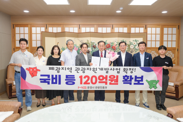 경북 유일 폐광지역인 문경이 강원도 폐광지역에만 국한됐던 폐광지역 관광자원개발사업 대상지에 확정돼 60억원의 신규 국비 등 120억원을 내년부터 지원 받는다. 이를 축하하기 위해 신현국 문경시장과 관련 직원들이 기념촬영을 하고 있다. 문경시 제공