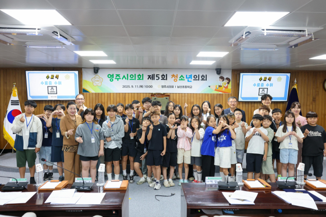 영주시의회가 운영한 청소년의회에 참여한 남산초등학교 학생들이 파이팅을 하며 기념사진을 촬영했다. 영주시의회 제공