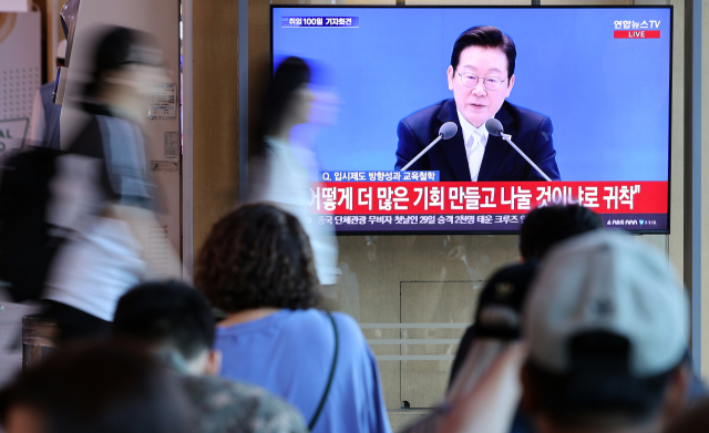 11일 오전 서울 용산구 서울역 대합실에서 시민들이 이재명 대통령 취임 100일 기자회견 방송을 보고 있다. 연합뉴스