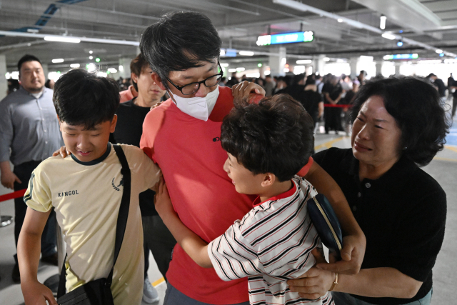 미국 이민당국에 의해 조지아주에 구금됐던 한국인 근로자가 12일 인천국제공항 제2여객터미널을 통해 귀국한 뒤 주차장에서 가족과 만나고 있다. 연합뉴스