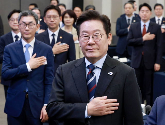 이재명 대통령과 참석자들이 15일 서울 성북구 한국과학기술연구원(KIST)에서 열린 핵심규제 합리화 전략회의에서 국기에 경례를 하고 있다. 연합뉴스