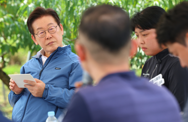 이재명 대통령이 16일 세종시 전동면 조일농원에서 열린 청년 농업인 간담회에서 참석자 발언을 메모하며 경청하고 있다. 연합뉴스