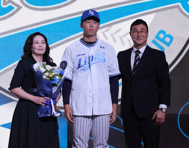 서울고 투수 이호범이 17일 서울 롯데호텔 월드에서 열린 2026 KBO 신인 드래프트에 참가, 삼성 라이온즈에 1라운드(전체 9순위) 지명을 받은 뒤 어머니, 이종열 삼성 단장과 함께 기념 사진을 찍고 있다. 연합뉴스