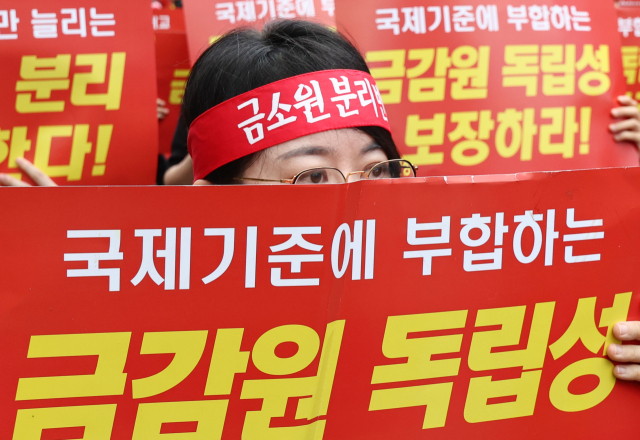 18일 서울 영등포구 여의도 국회의사당역 앞에서 열린 금융감독원 금융소비자보호원 분리 및 금융감독원 공공기관 지정 반대 집회에서 금감원 노동조합원들이 손팻말을 들고 있다. 연합뉴스