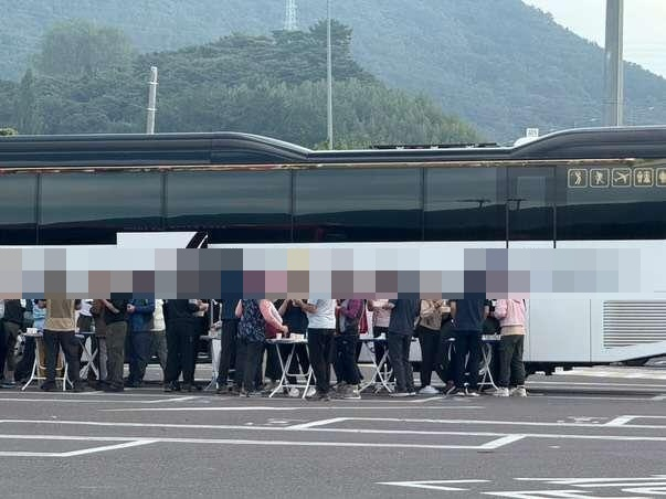 남해고속도로 진영휴게소 주차장에서 단체 관광객들이 버스 옆에 테이블을 펼쳐놓고 음주를 하는 장면이 포착돼 비판이 이어지고 있다. 온라인 커뮤니티