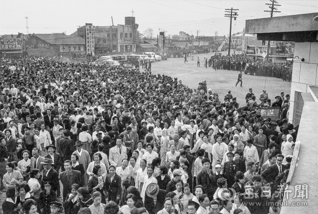 1962년 10월 24일 오전 제43회 전국체육대회 개막식장인 대구종합운동장을 찾은 시도민들이 관중석 만석으로 정문이 봉쇄되자 2.5m 담장을 넘어 들어가려는 젊은이들을 구경하고 있다. 사진=매일아카이빙센터