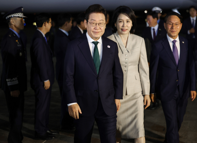 미국 방문 일정을 마치고 귀국한 이재명 대통령과 김혜경 여사가 26일 성남 서울공항에 착륙한 공군 1호기에서 내려 이동하고 있다. 연합뉴스