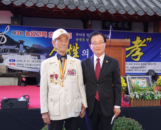 김혁종(오른쪽) 선산김씨 농암파 종친회장이 효 공감대상 수상자 김화출 전 6.25참전유공자회 구미시지회장에게 격려금을 전달하기 전 기념촬영을 하고 있다. 선산김씨 농암파 종친회 제공