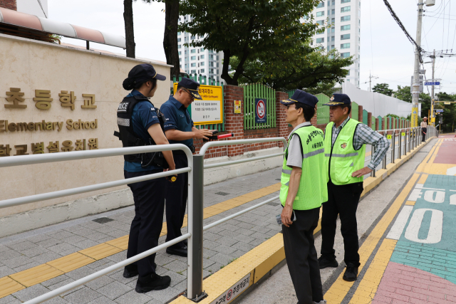 최근 초등학생 납치 미수 등 아동 대상 범죄가 잇따르는 가운데 12일 서울의 한 초등학교 앞에 경찰이 배치되어 있다. 연합뉴스