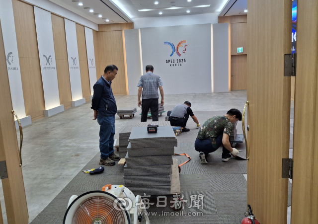 APEC 정상회의가 열리는 경주화백컨벤션센터에서 29일 오후 작업자들이 회의장 내 새 카펫을 깔고 있다. 김진만 기자