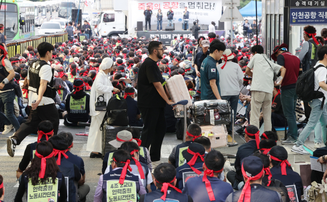 1일 서울 강서구 김포국제공항 국내선 청사 앞에서 외국인이 이동하고 있다. 이날 청사 앞에서는 전국공항노동자 총파업 대회가 열렸다. 연합뉴스
