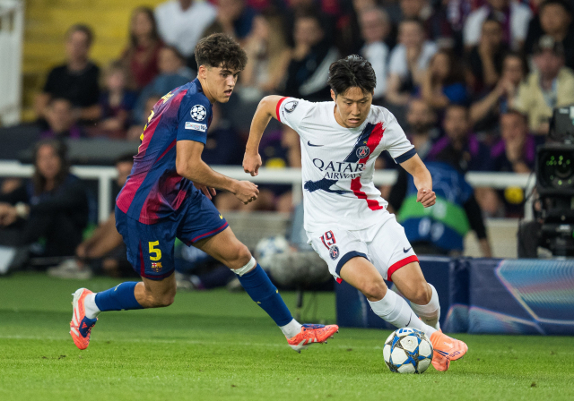 PSG의 이강인이 2일 스페인 바르셀로나에서 열린 2025-2026 UEFA UCL 리그 페이즈 2차전에 출전해 바르셀로나의 파우 쿠바르시를 따돌리며 드리블로 전진하고 있다. 연합뉴스