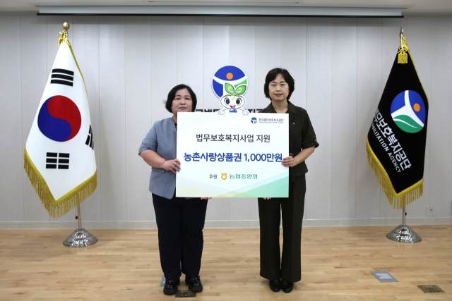 권정희(오른쪽) 농협은행 김천드림밸리 지점장이 이현미 한국법무보호복지공단 이사장 직무대리에게 농촌사랑상품권 1천만원을 전달한 뒤 기념촬영을 하고 있다. 한국법무보호복지공단 제공