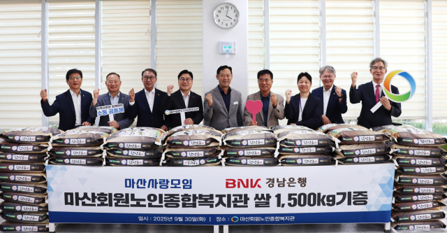 BNK경남은행 허종구 부행장(사진 왼쪽 네번째), 마산사랑모임 한철수 회장, 정영노 후원이사회 회장, 창원시 마산회원구 제종남 구청장, 마산회원노인종합복지관 정응석 관장 등이 쌀 기증식에 참석해 단체 기념촬영을 하고 있다.