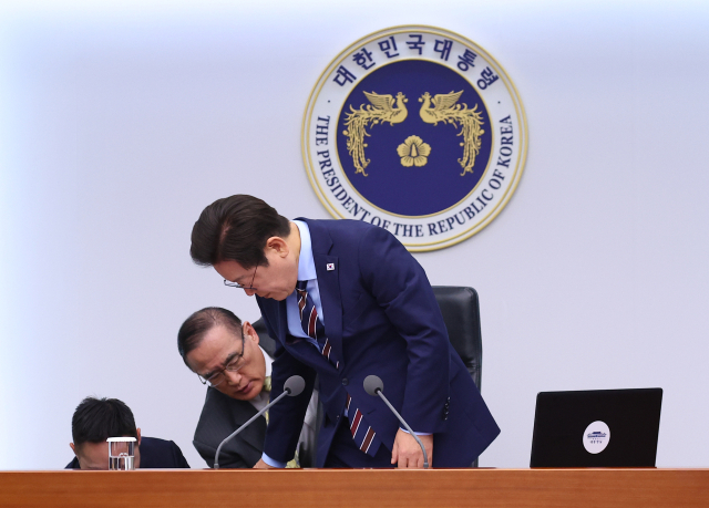 위성락 국가안보실장이 2일 용산 대통령실에서 열린 수석보좌관회의에서 이재명 대통령의 의자 높이 조절이 제대로 되지 않자 이를 직접 도와주고 있다. 연합뉴스