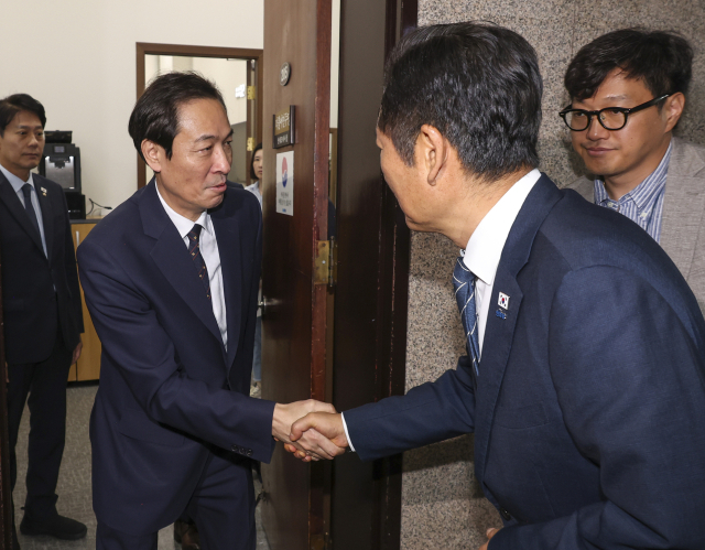 더불어민주당 정청래 대표(오른쪽)와 우상호 대통령실 정무수석이 25일 국회 민주당 대표실에서 금융정책·감독분리 관련 긴급 고위 당·정·대 회의를 마친 뒤 악수하고 있다. 연합뉴스