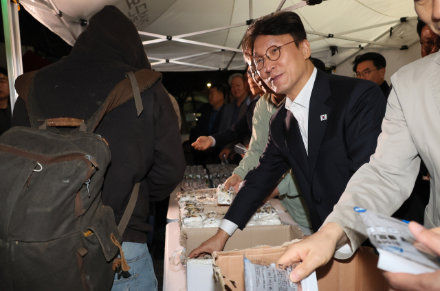 김민석 국무총리가 10일 서울 구로구 남구로 새벽인력시장을 찾아 근로자들에게 떡을 나눠주고 있다. 연합뉴스