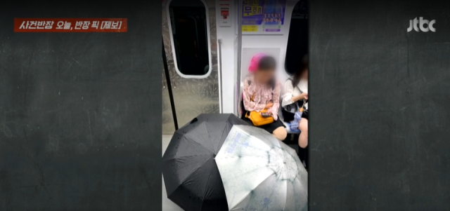 지난 5일 서울 지하철 5호선 객차 안에서 중국인으로 추정되는 여성이 임신부석에 앉은 채 젖은 우산을 펼쳐 말리고 있다. JTBC