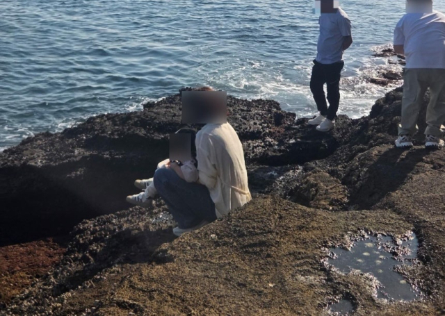 지난 6일 제주 서귀포시 안덕면 용머리해안에서 아이의 용변을 보게 한 중국인 관광객의 모습. 보배드림 캡처