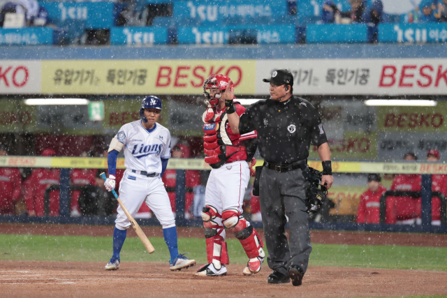 삼성 라이온즈의 김지찬이 13일 대구에서 열린 프로야구 준플레이오프 3차전 SSG 랜더스와의 경기 1회말 갑작스런 폭우로 경기가 중단되자 타석에서 물러나고 있다. 삼성 제공