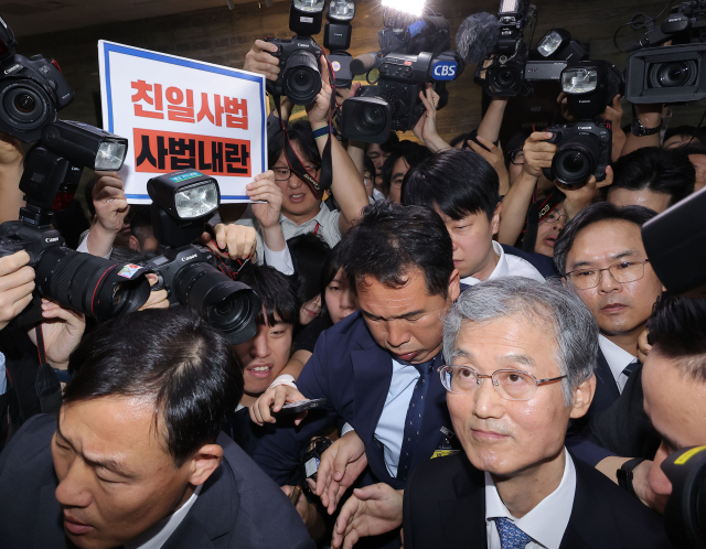 조희대 대법원장이 13일 서울 여의도 국회에서 열린 대법원 등에 대한 법제사법위원회 국정감사에서 정회가 선언되자 법사위 회의실을 나서고 있다. 왼쪽 위는 조 대법원장의 이석에 반대하며 무소속 최혁진 의원이 든 규탄 팻말. 연합뉴스