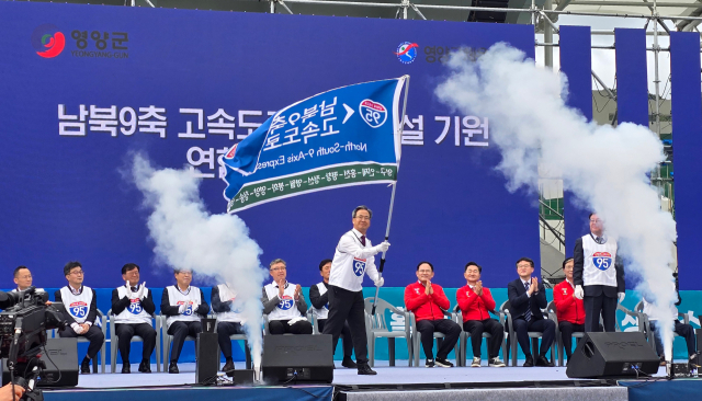 오도창 영양군수가 15일 남북9축 고속도로 조기 건설 기원 연합 퍼포먼스식에서 강원도에서 경북을 연결하는 10개 지자체의 이름이 담김 고속도로 표지판 모양의 깃발을 흔들고 있다. 김영진 기자