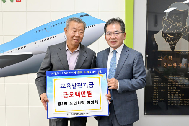 대구 군위군 군위읍 정3리 이병희(왼쪽) 노인회장이 군위군에 교육발전기금을 기탁하고, 김진열(오른쪽) 군수와 기념 사진을 촬영하고 있다. 군위군 제공