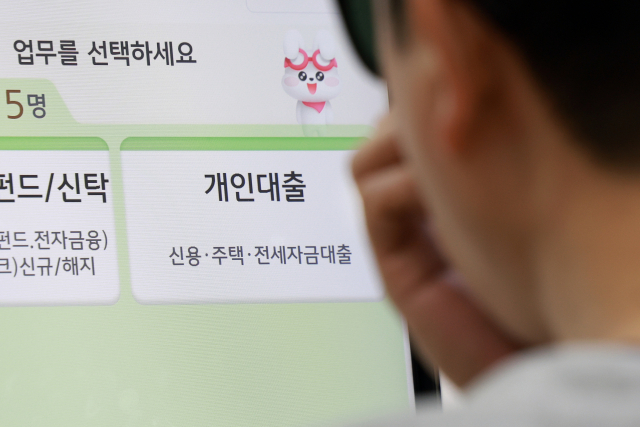 정부가 부동산시장 안정 대책을 발표한 15일 서울 시내 시중은행을 찾은 시민이 상담 받기 위해 번호표를 뽑고 있다. 연합뉴스