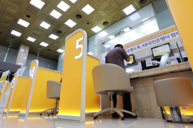 정부가 부동산시장 안정 대책을 발표한 15일 서울 시내 시중은행을 찾은 시민이 창구에서 상담 받는 모습. 내일부터 수도권·규제지역의 시가 15억 초과∼25억원 미만 주택은 주담대 한도가 4억원, 25억원 초과 주택은 2억원으로 각각 줄어든다. 그간 대출 규제에서 제외돼온 1주택자의 전세대출도 이달부터 총부채원리금상환비율에 반영된다. 대출 한도 축소 효과를 내는 스트레스 금리의 하한이 현재 1.5%에서 수도권·규제지역 주담대에는 3%로 상향 조정되고, 은행권 주담대 위험가중치 하한 상향 조치를 시행하는 시기도 앞당겨진다. 연합뉴스