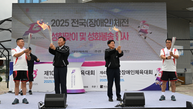 정종복 기장군수(오른쪽)와 박홍복 기장군의회 의장이 성화봉송 주자에게 성화를 전달하고 있다. [사진=기장군]