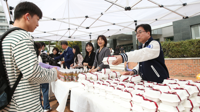 성한기 대구가톨릭대 총장이 중간고사 기간을 맞아 중앙도서관 앞에서 학생들에게 간식을 나눠주며 응원의 인사를 전하고 있다. 대구가톨릭대 제공