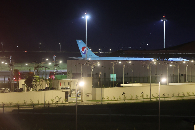 캄보디아 온라인 사기에 가담해 구금된 한국인들 탑승한 버스가 17일(현지시간) 캄보디아 프놈펜 인근 테초국제공항에서 송환을 위해 마련된 전세기로 향하고 있다. 한국인 64명을 송환하기 위해 경찰 호송조 190여명이 함께 탄 이 대한항공 전세기는 이날 오전 0시 30분께 다시 한국으로 출발해 오전 중 도착할 예정이다. 연합뉴스