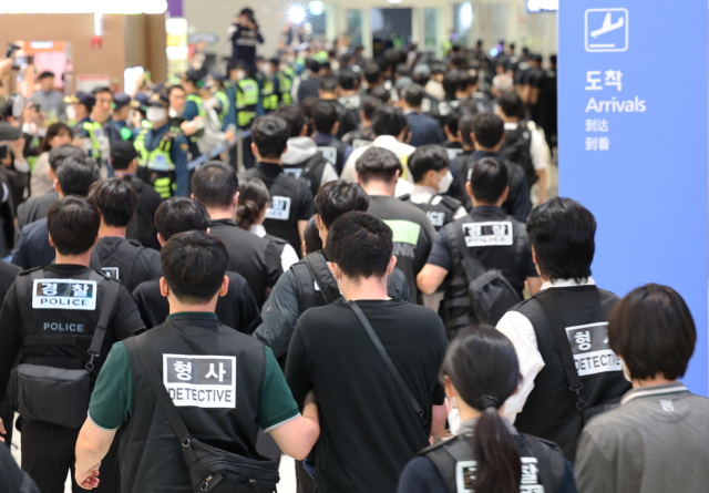 캄보디아 온라인 사기에 가담해 구금된 한국인들이 18일 오전 인천국제공항 제2터미널을 통해 송환되고 있다. 이날 송환에는 경찰 호송조 190여명이 투입됐다. 연합뉴스