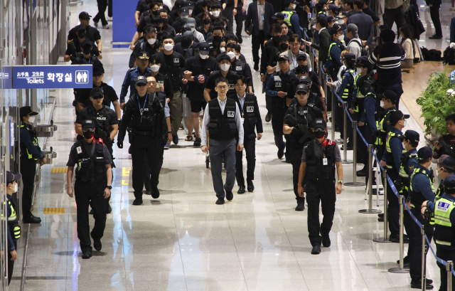 캄보디아 온라인 사기에 가담해 구금된 한국인들이 18일 오전 인천국제공항 제2터미널을 통해 송환되고 있다. 이날 송환에는 경찰 호송조 190여명이 투입됐다. 연합뉴스