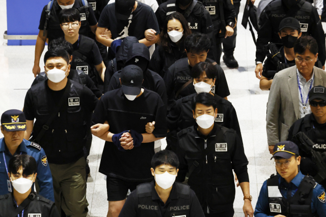 캄보디아 온라인 사기에 가담해 구금된 한국인들이 18일 오전 인천국제공항 제2터미널을 통해 송환되고 있다. 이날 송환에는 경찰 호송조 190여명이 투입됐다. 연합뉴스