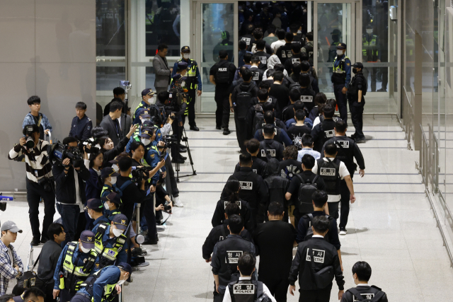 캄보디아 온라인 사기에 가담해 구금된 한국인들이 18일 오전 인천국제공항 제2터미널을 통해 송환되고 있다. 이날 송환에는 경찰 호송조 190여명이 투입됐다. 연합뉴스