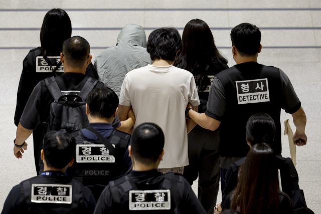 캄보디아 온라인 사기에 가담해 구금된 한국인들이 18일 오전 인천국제공항 제2터미널을 통해 송환되고 있다. 이날 송환에는 경찰 호송조 190여명이 투입됐다. 연합뉴스