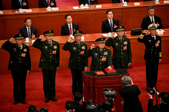 2023년 3월 11일 중국 베이징 인민대회당에서 열린 전국인민대표대회(전인대)에서 장유샤 중앙군사위 부주석 등 새로 선출된 중앙군사위원들이 함께 선서를 하고 있는 모습. 로이터 연합뉴스