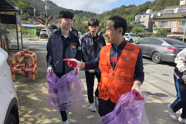 지난 17일 김칠규 구미시 마이스터멘토단 단장이 구미전자공고 학생들과 구미시 고아읍 예강1리 마을을 청소하고 있다. 조규덕기자