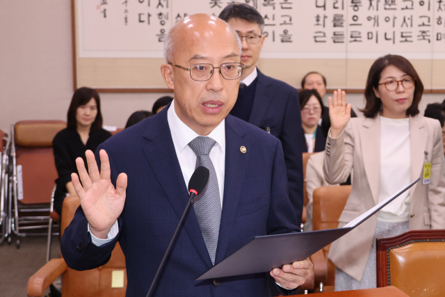 조원철 법제처장이 24일 서울 여의도 국회 법제사법위원회에서 열린 법제처에 대한 국정감사에서 증인선서를 하고 있다. 사진 상 맨 뒤 우측엔 윤석열 정부 때 이완규 전 법제처장. 연합뉴스
